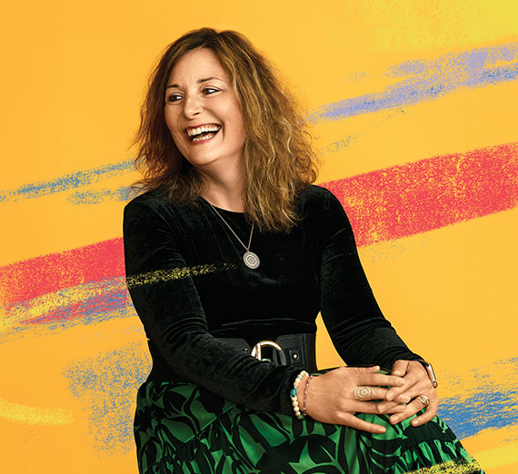 Two people study a plant in a greenhouse.